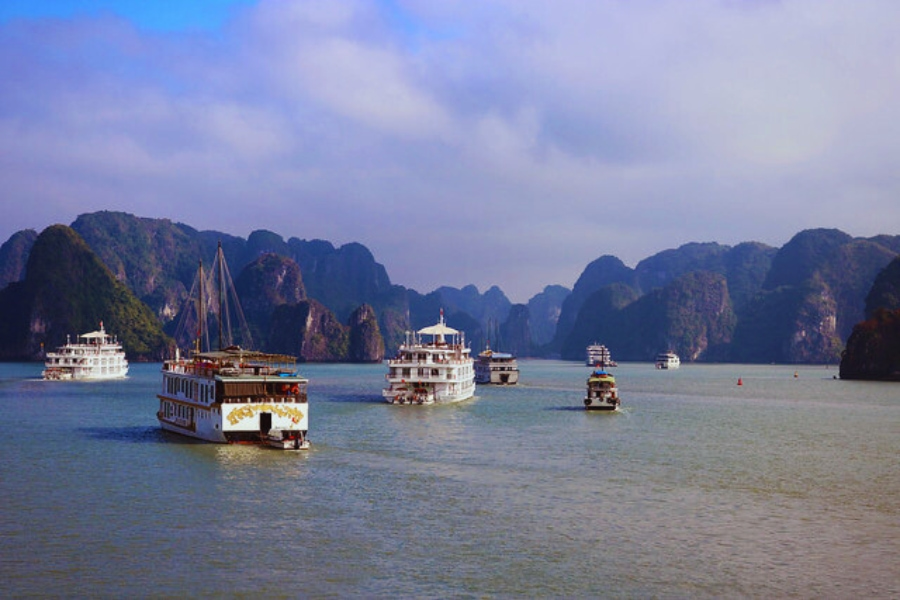 Budget Halong Bay Cruise boats sailing among limestone karsts with Auasia Travel